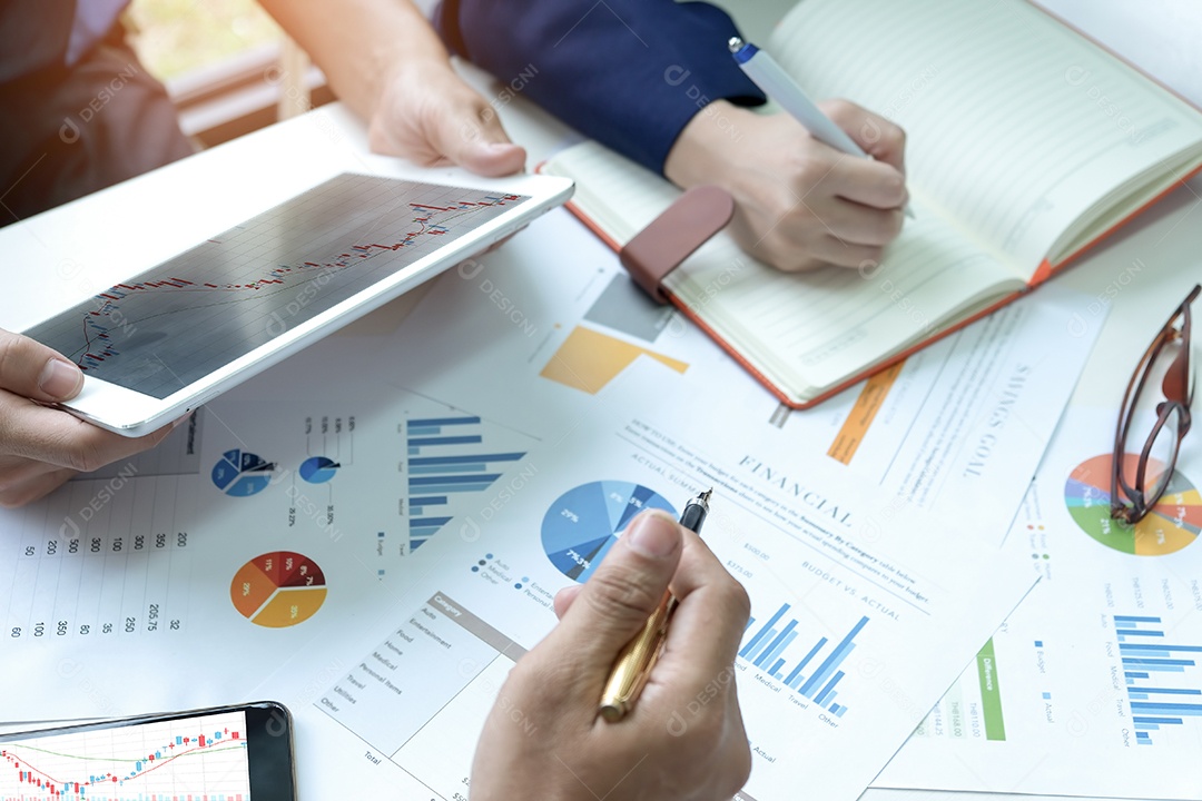 Equipe de negócios está analisando gráficos. Eles usam um tablet e a secretária faz anotações.