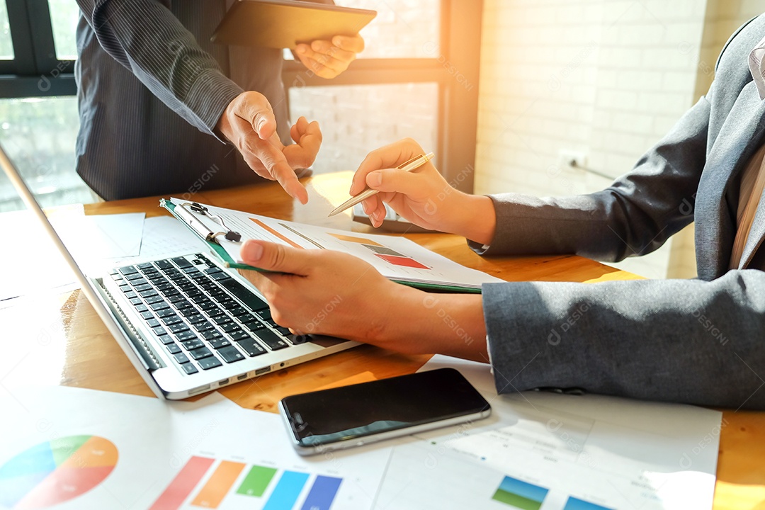 Dois homens de negócios apontando para um gráfico para analisar dados.