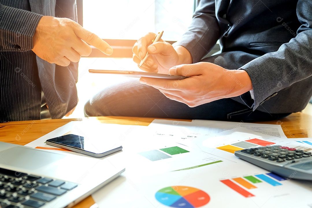 Dois empresários masculinos analisam dados com um tablet. com um gráfico na mesa.