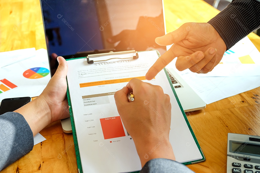 Dois homens de negócios apontando para um gráfico para analisar dados.