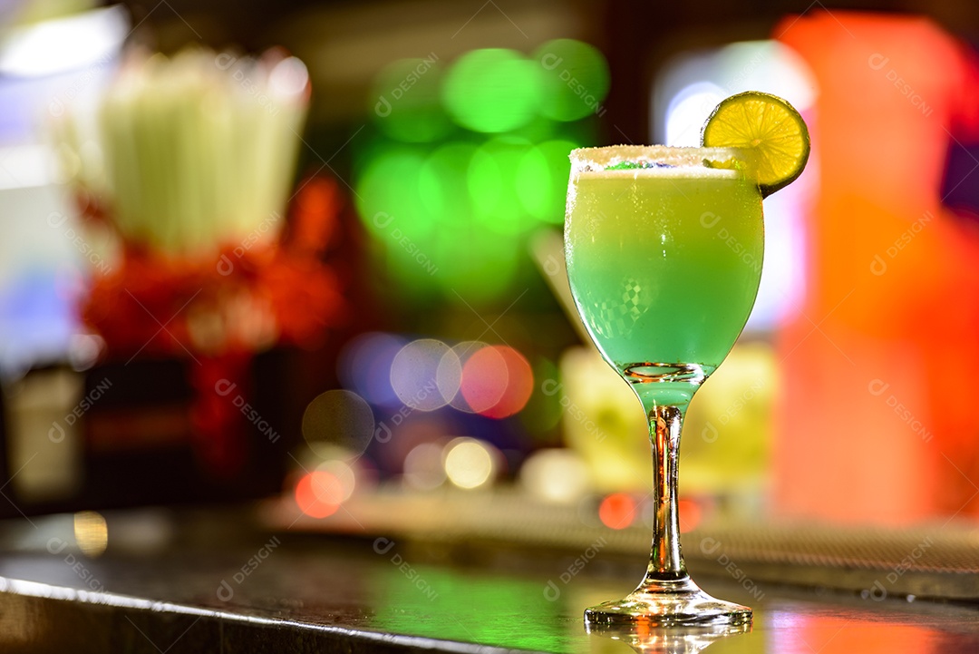 Coquetel no balcão do bar com luzes coloridas desfocadas ao fundo.