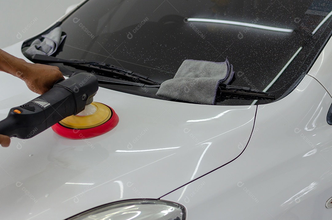 Homem trabalhando para polir, revestir carros.
