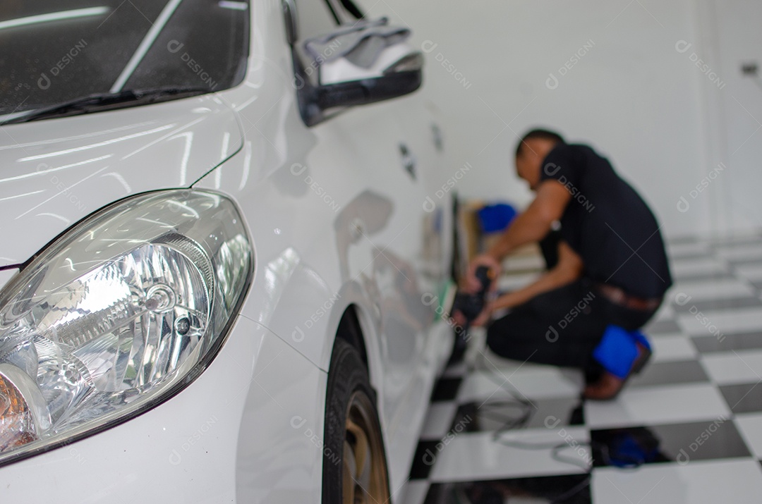 Homem trabalhando para polir, revestir carros.