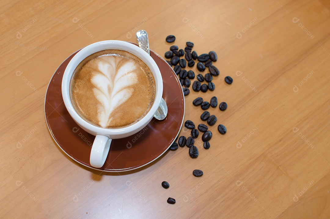 Café na mesa, xícara bonita e grãos de café