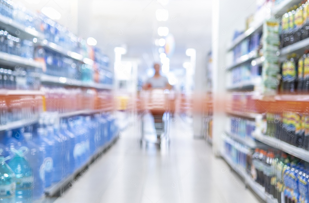 Corredor de supermercado turva com prateleiras de mercadorias. Visão em perspectiva do corredor abstrato da mercearia - cliente mulher com carrinho de compras no meio - conceito de compras de varejo