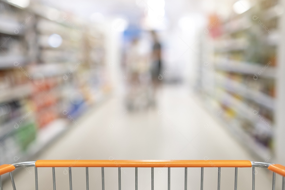 Corredor de supermercado turva com prateleiras de mercadorias e um carrinho de compras em primeiro plano - Visão de perspectiva embaçada do corredor abstrato da mercearia - conceito de compras de varejo - foco seletivo