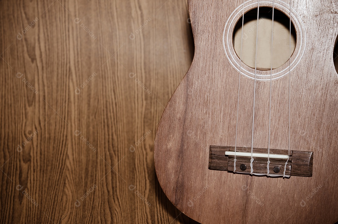 O ukulele é colocado em um piso de madeira vintage.