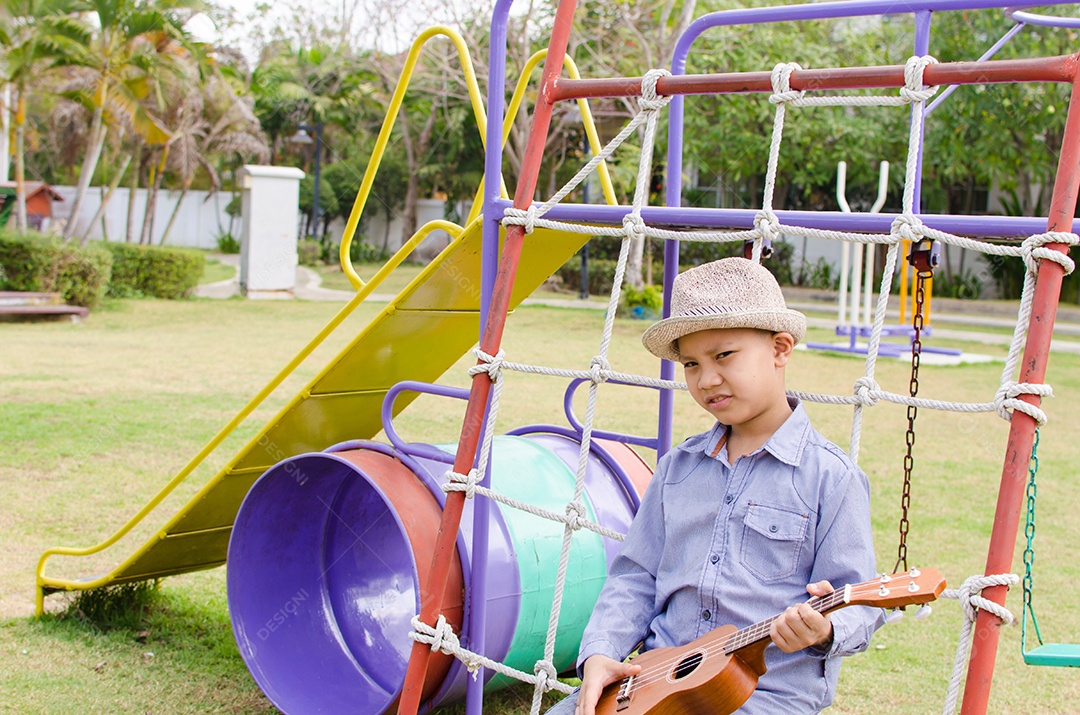 Brincadeira de criança no ukulele em parque