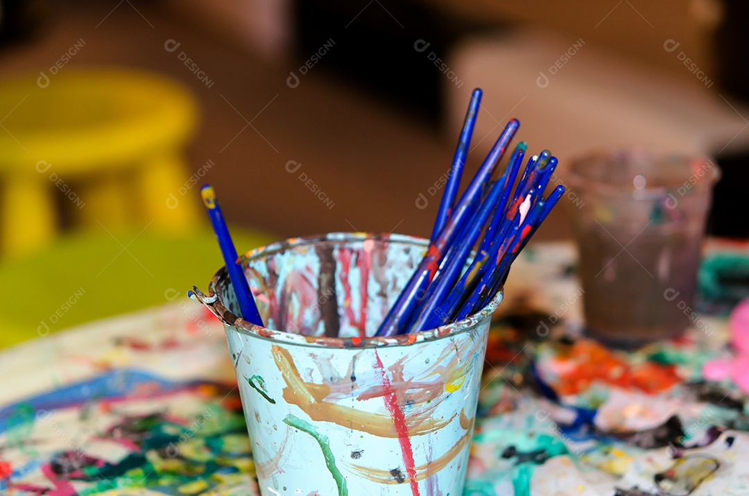 Garrafa de aquarelas colocada na mesa manchada.