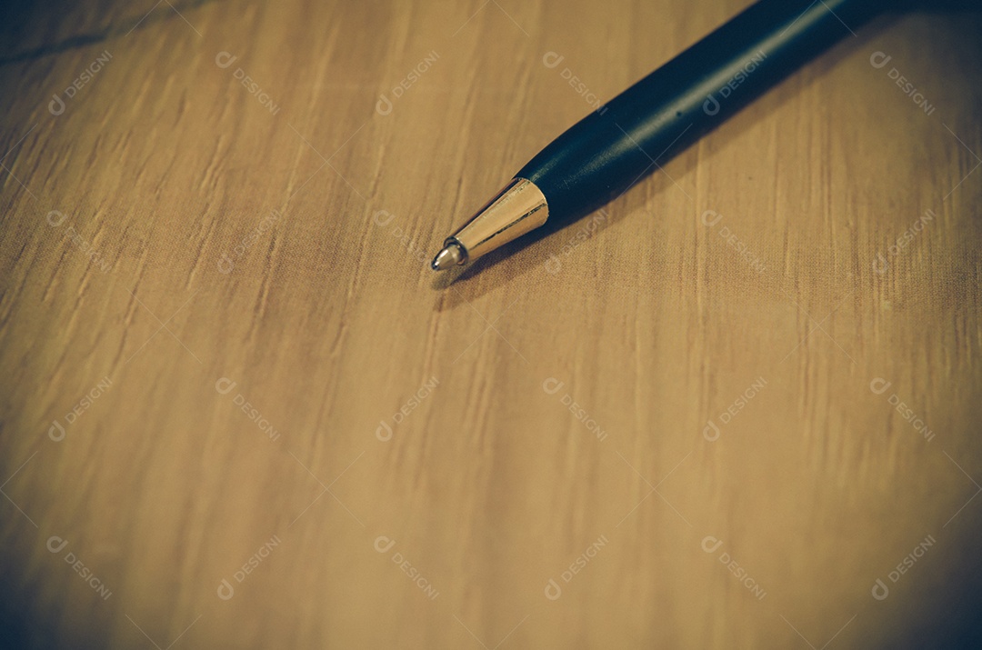 Caneta vintage no livro marrom na mesa.