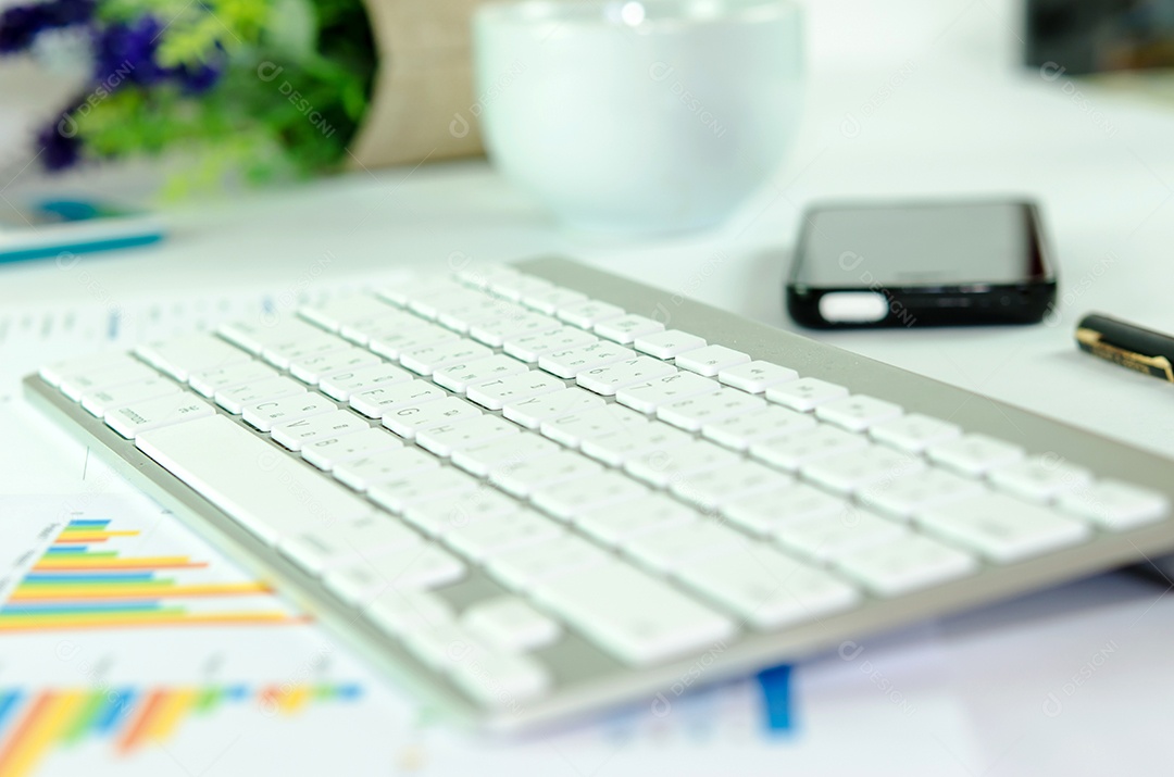 Close-up de documentos de teclado e café na mesa de escritório.