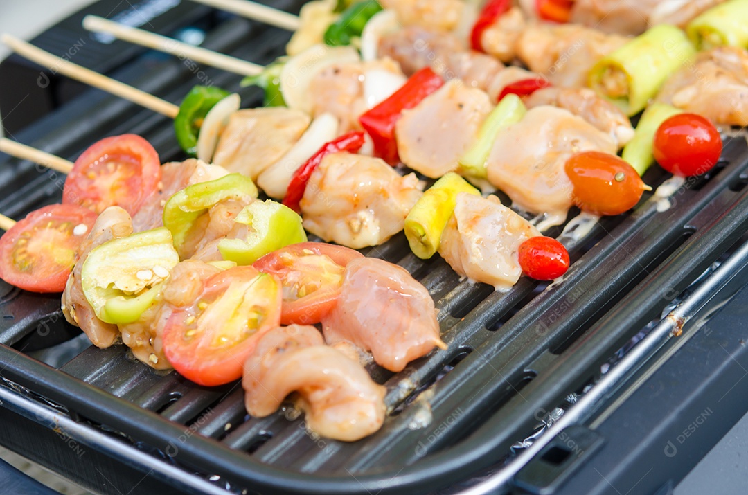 Grelhar frango na churrasqueira elétrica.