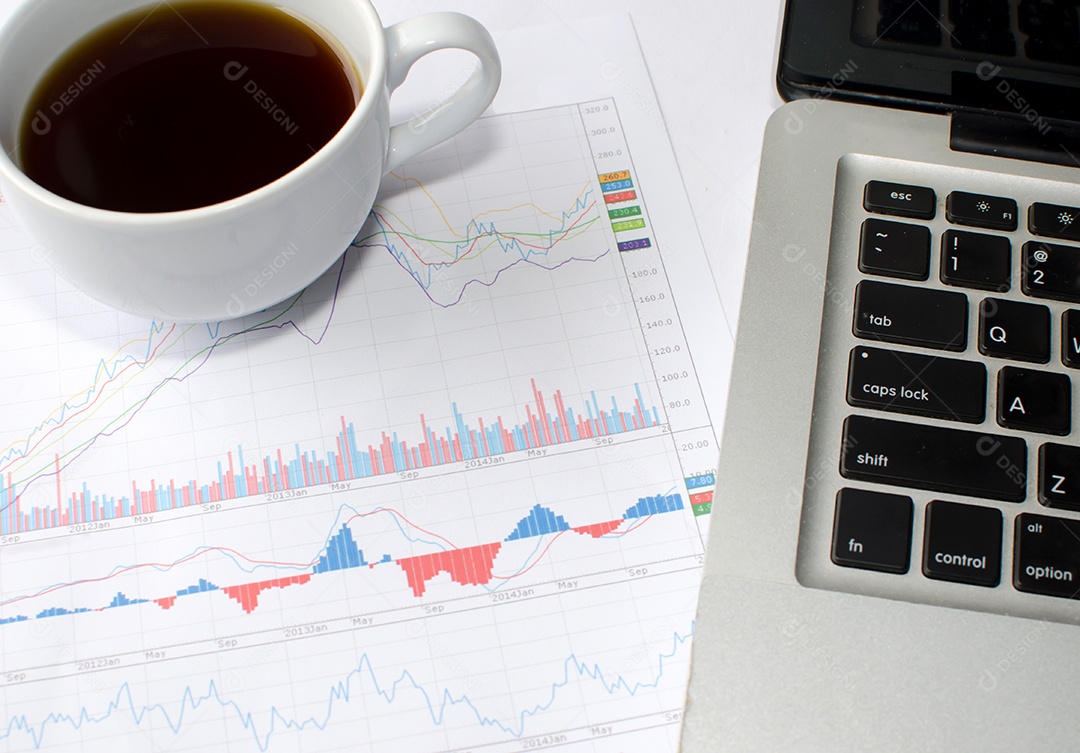 Gráfico de papel e computador na mesa.