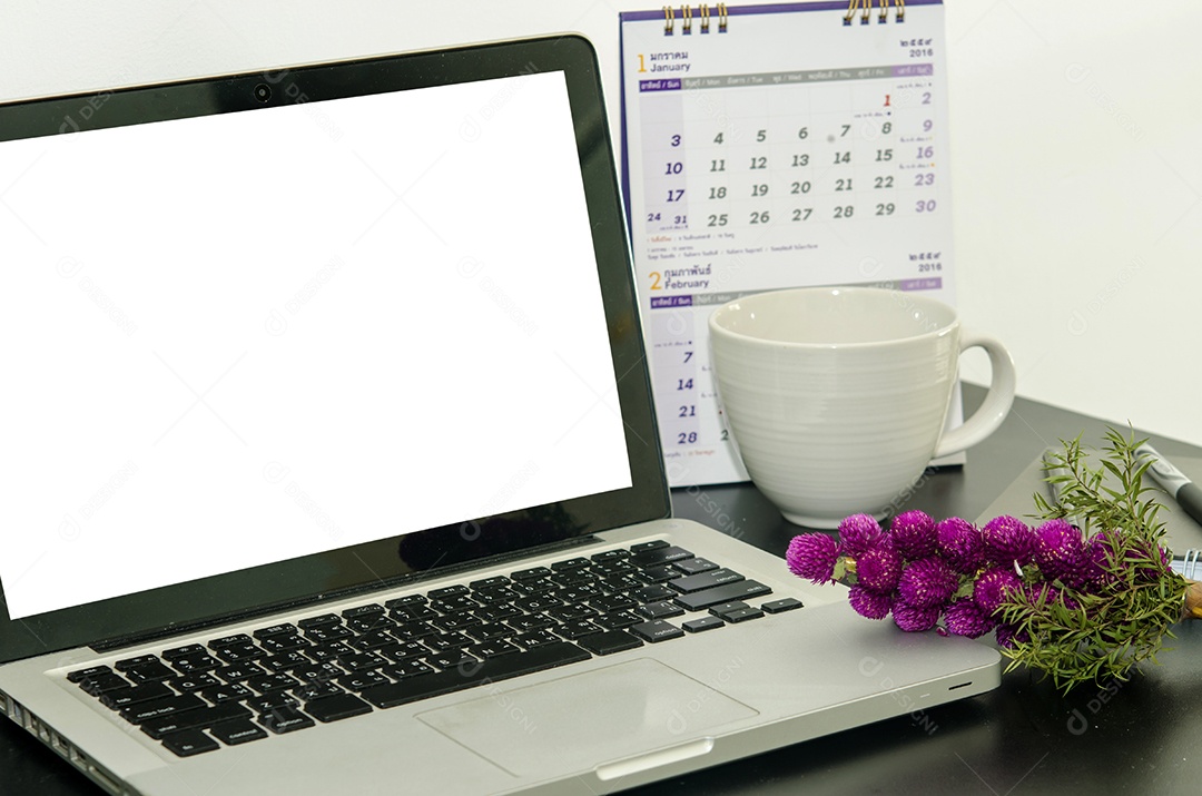 Um caderno, laptop, xícara de café, caneta, na mesa do escritório.