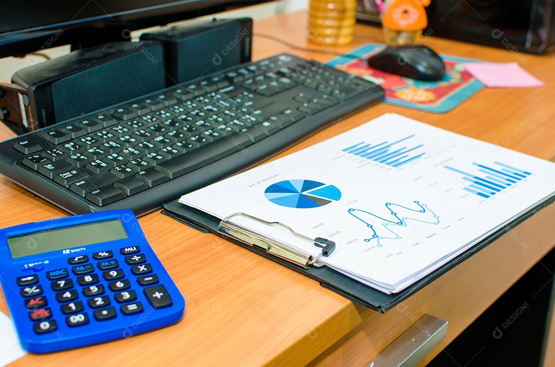Gráfico e computador na mesa de madeira