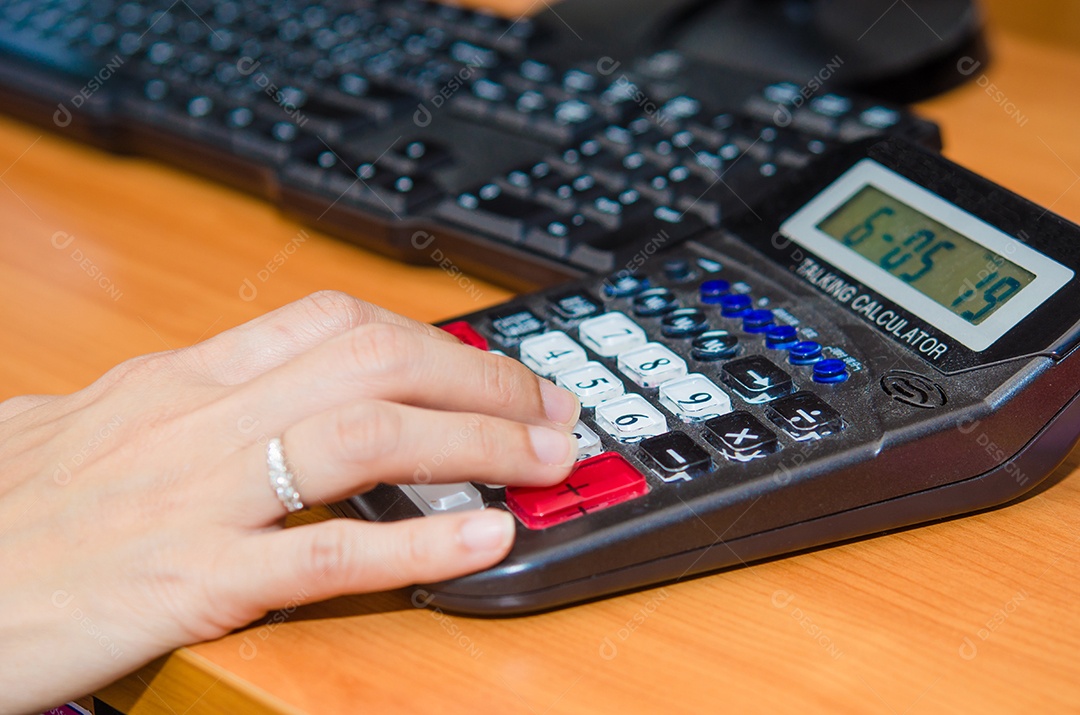 Análise de dados financeiros. Foto de close-up da mão de uma empresária na calculadora no escritório. Foco seletivo
