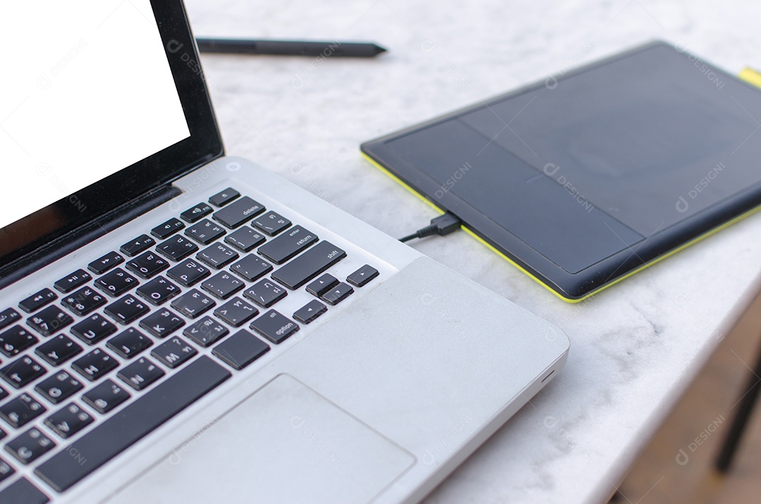 Tablets de notebook e caneta na mesa.