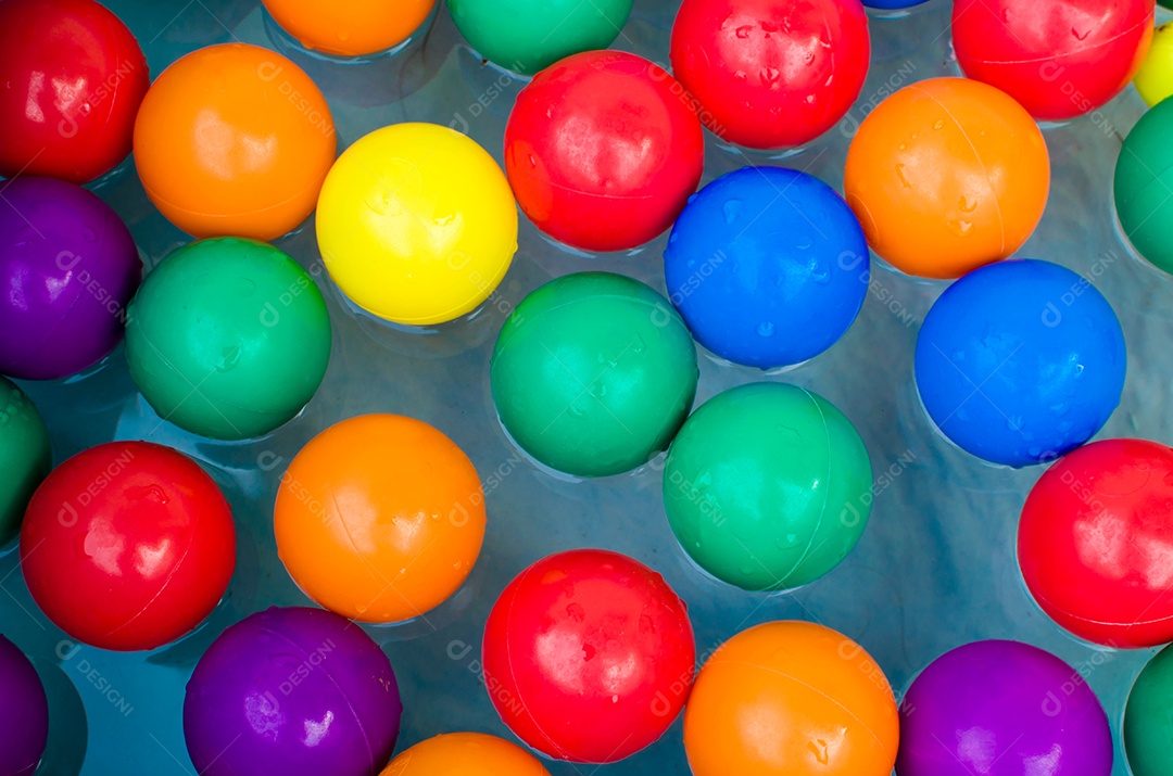 Bolas de brinquedo coloridas na piscina com água.