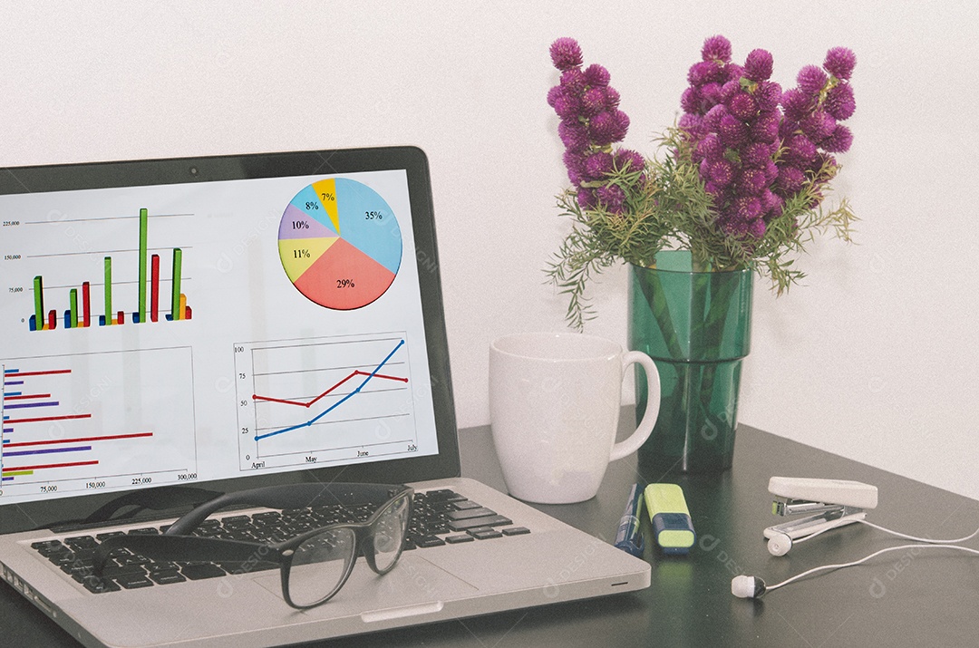 Computador e gráfico na mesa de madeira .