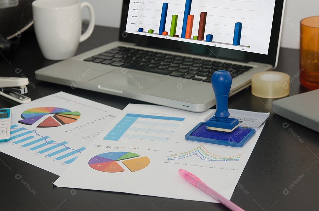 Computador e gráfico na mesa de madeira .