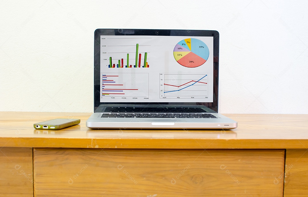 Computador e gráfico na mesa de madeira .