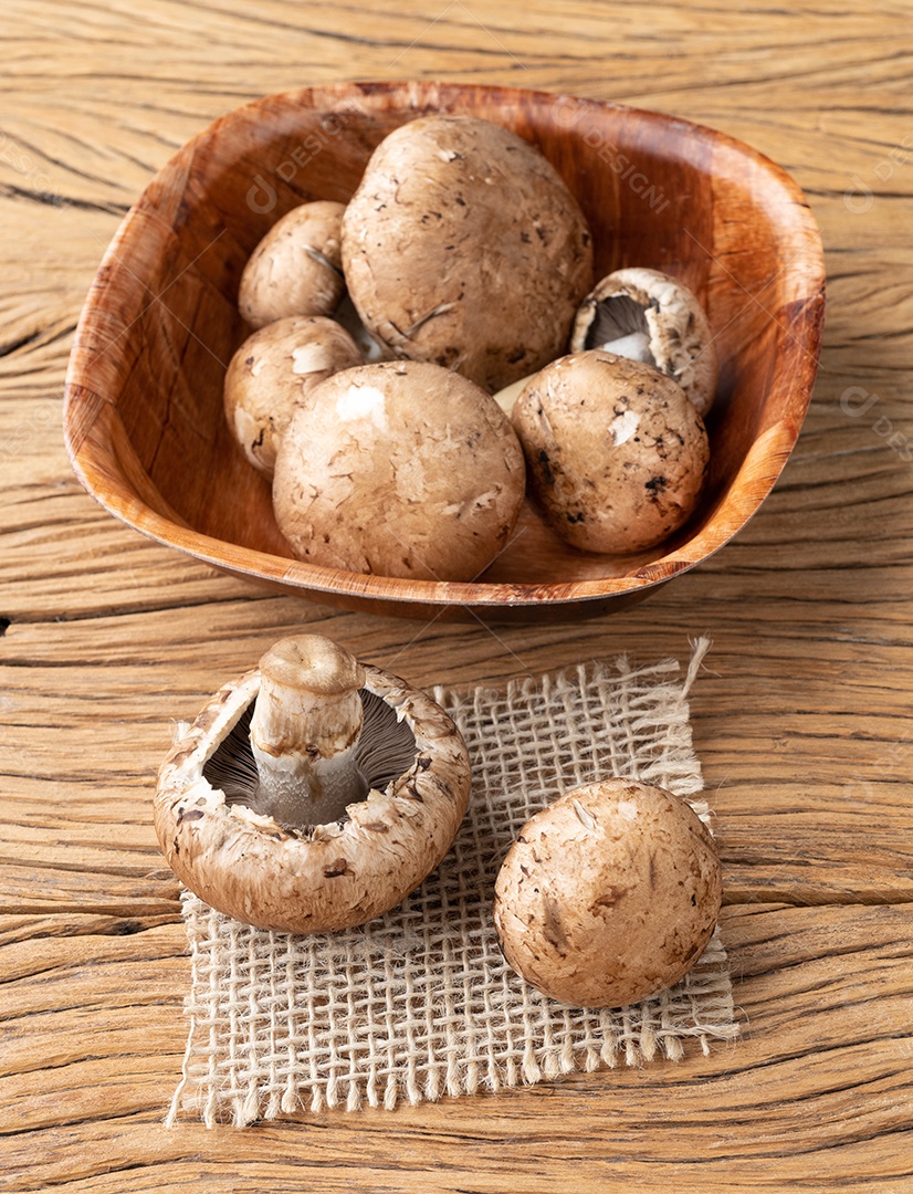 Cogumelos Portobello em uma tigela sobre a mesa de madeira.