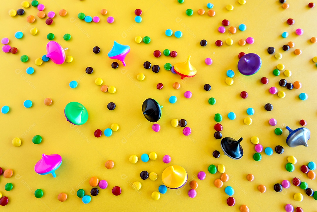 Chocolates e brinquedos em um fundo amarelo, feliz dia das crianças