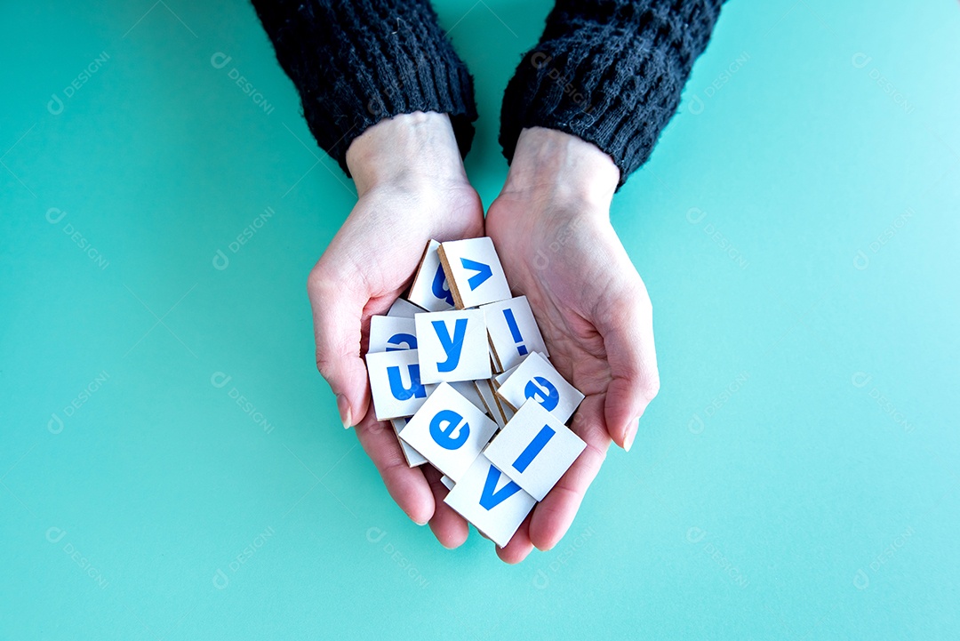 Mãos femininas segurando cartas sobre fundo verde, crianças felizes