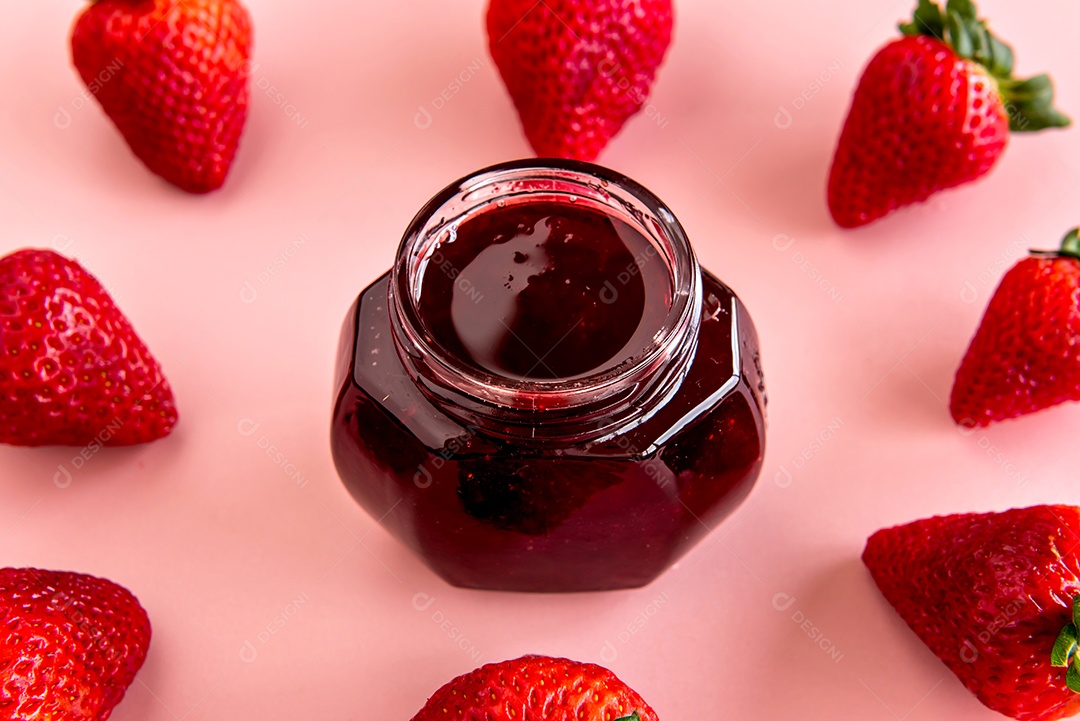 Morangos e geleia de morango em fundo rosa