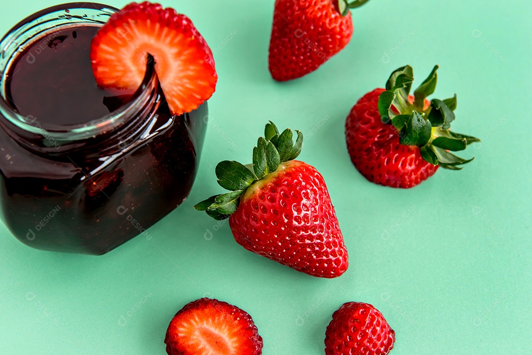 Morangos e geleia de morango em fundo rosa