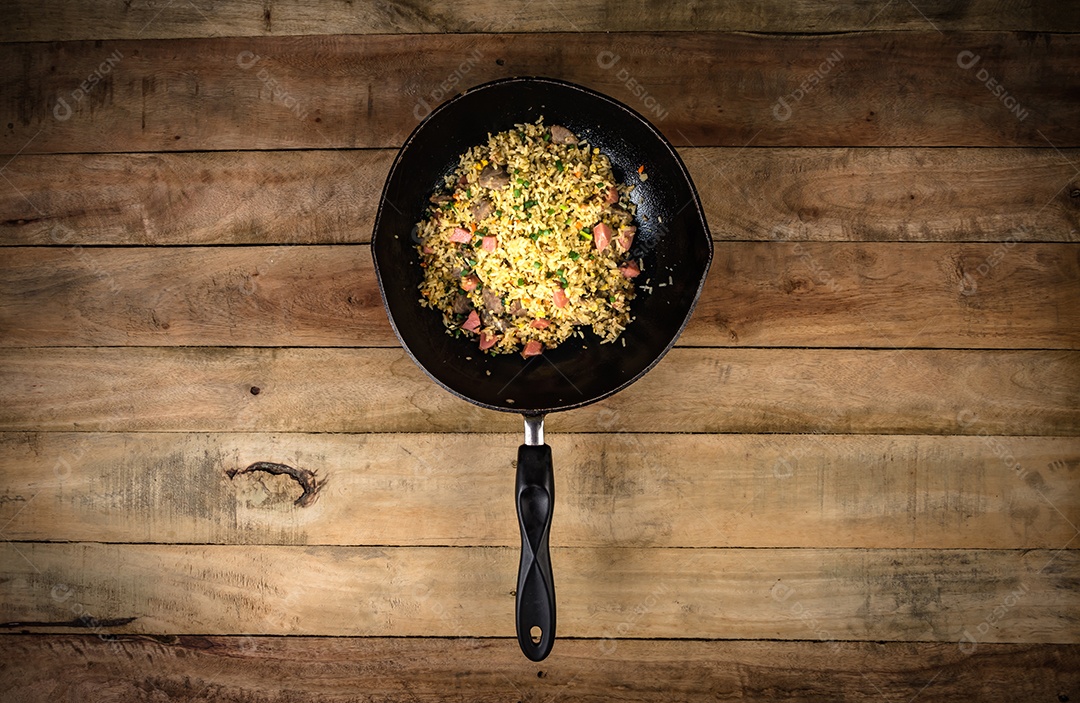 arroz frito com legumes, carne e ovos fritos servido em um prato com pauzinhos