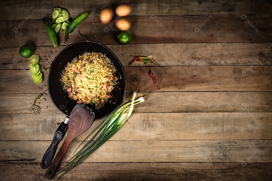 arroz frito com legumes, carne e ovos fritos servido em um prato com pauzinhos
