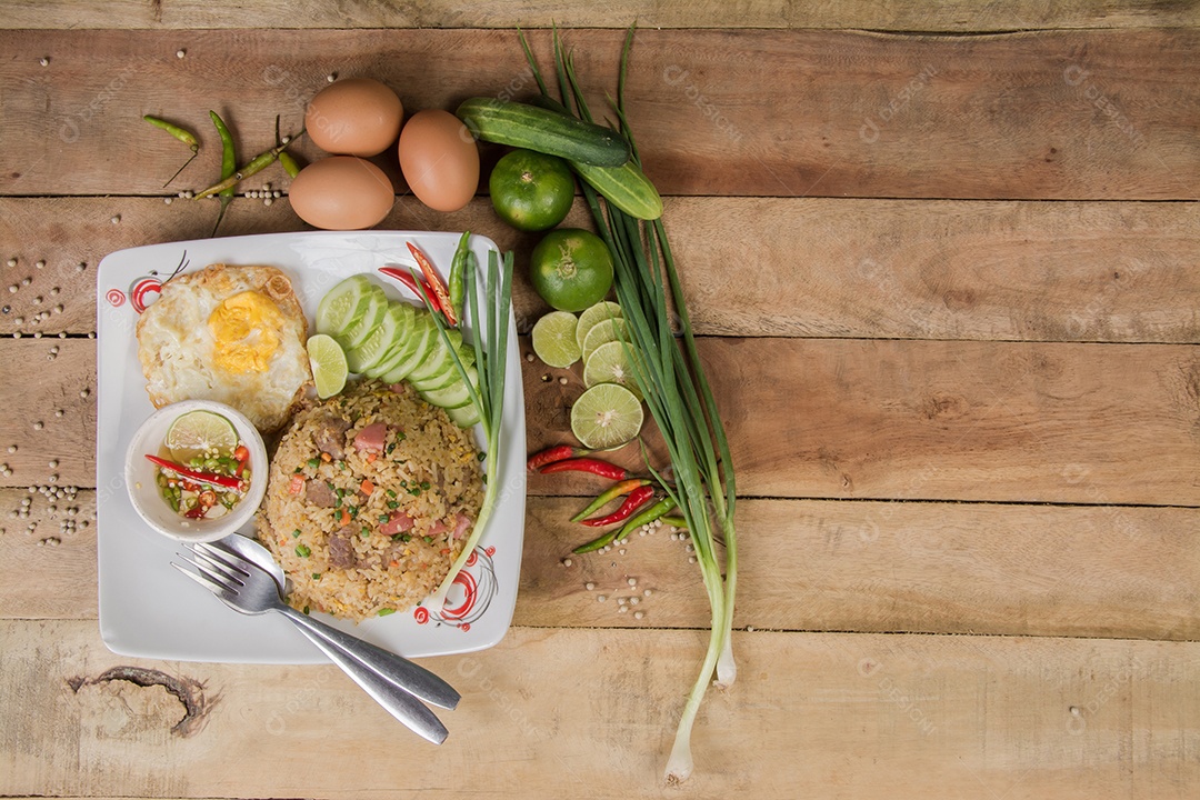arroz frito com legumes, carne e ovos fritos servido em um prato com pauzinhos