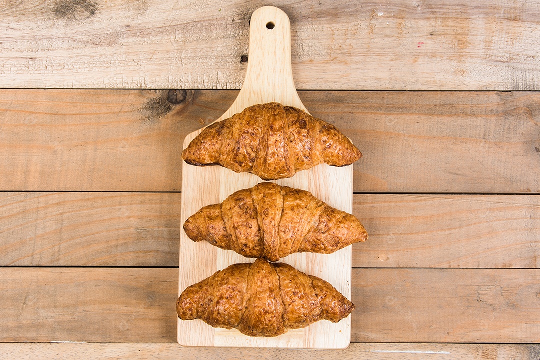 croissants recém-assados ​​em uma tábua de madeira