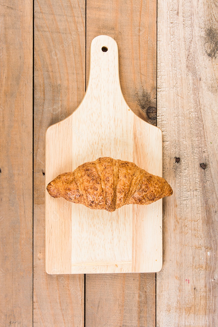 croissants recém-assados ​​em uma tábua de madeira