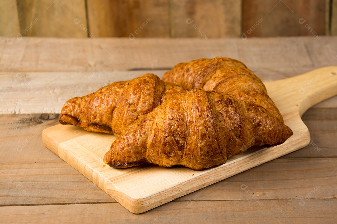 croissants recém-assados ​​em uma tábua de madeira