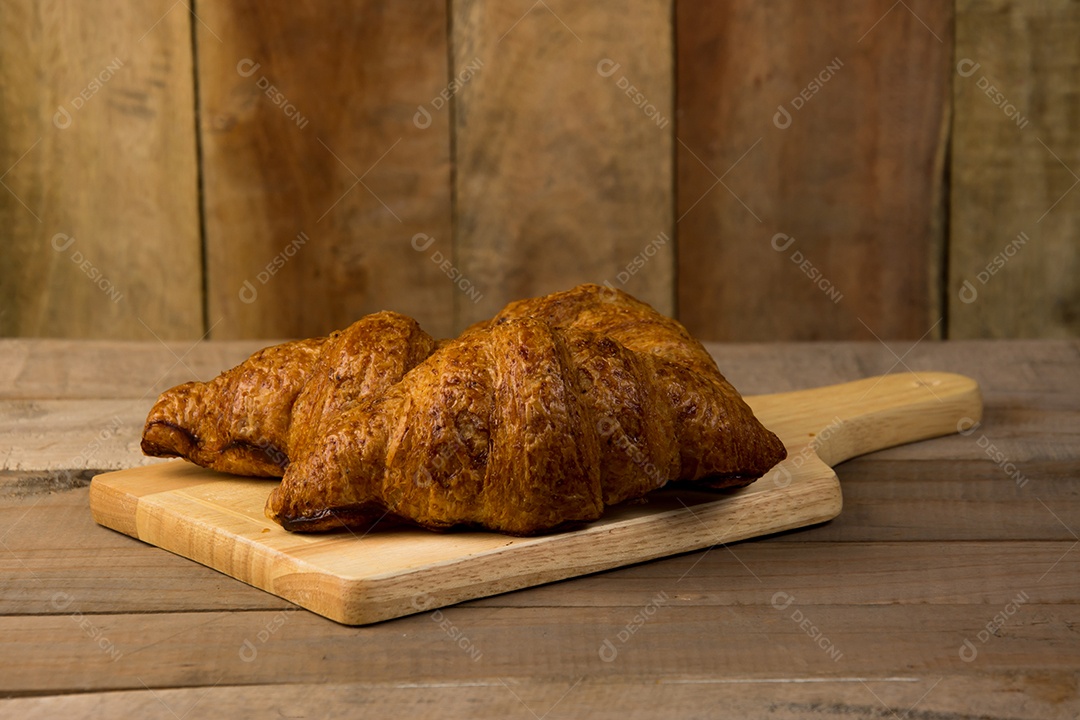 croissants recém-assados ​​em uma tábua de madeira