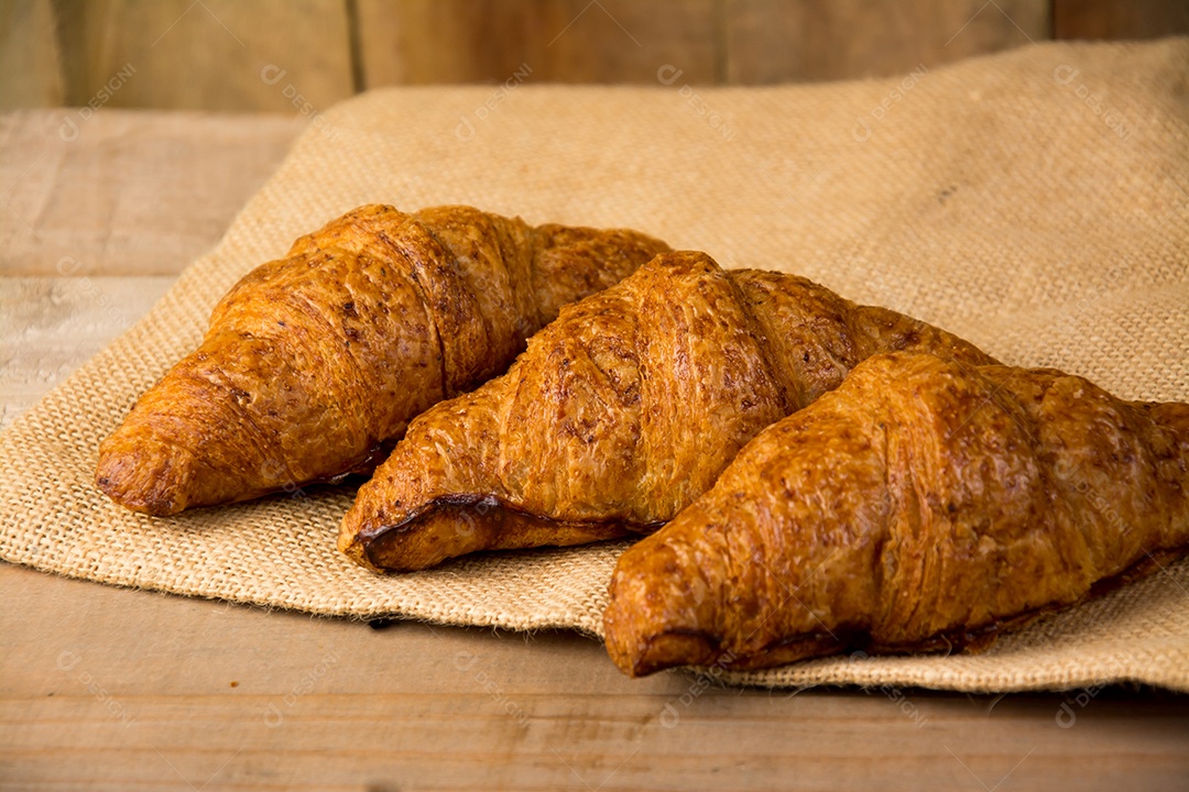 croissants recém-assados ​​em uma tábua de madeira