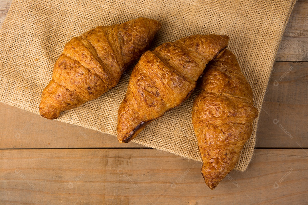 croissants recém-assados ​​em uma tábua de madeira