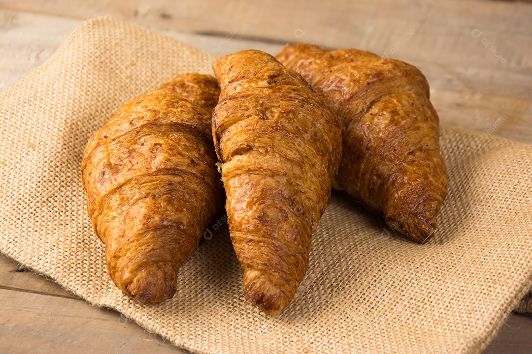 croissants recém-assados ​​em uma tábua de madeira