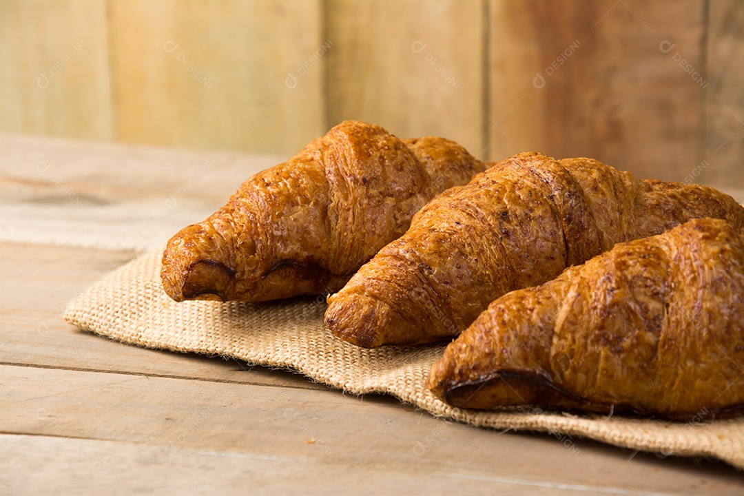 croissants recém-assados ​​em uma tábua de madeira