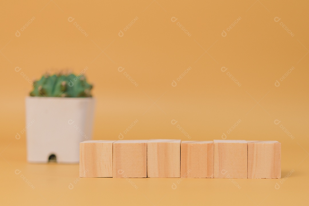 Bloco de cubo de madeira em branco e árvore em fundo amarelo.