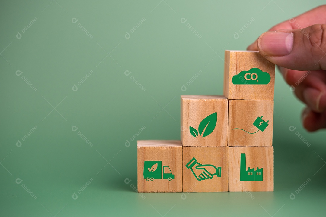 Mão segurando o ícone de bloco de cubo de madeira crédito de carbono co2 e tecnologia verde de energia ecológica sobre fundo verde.