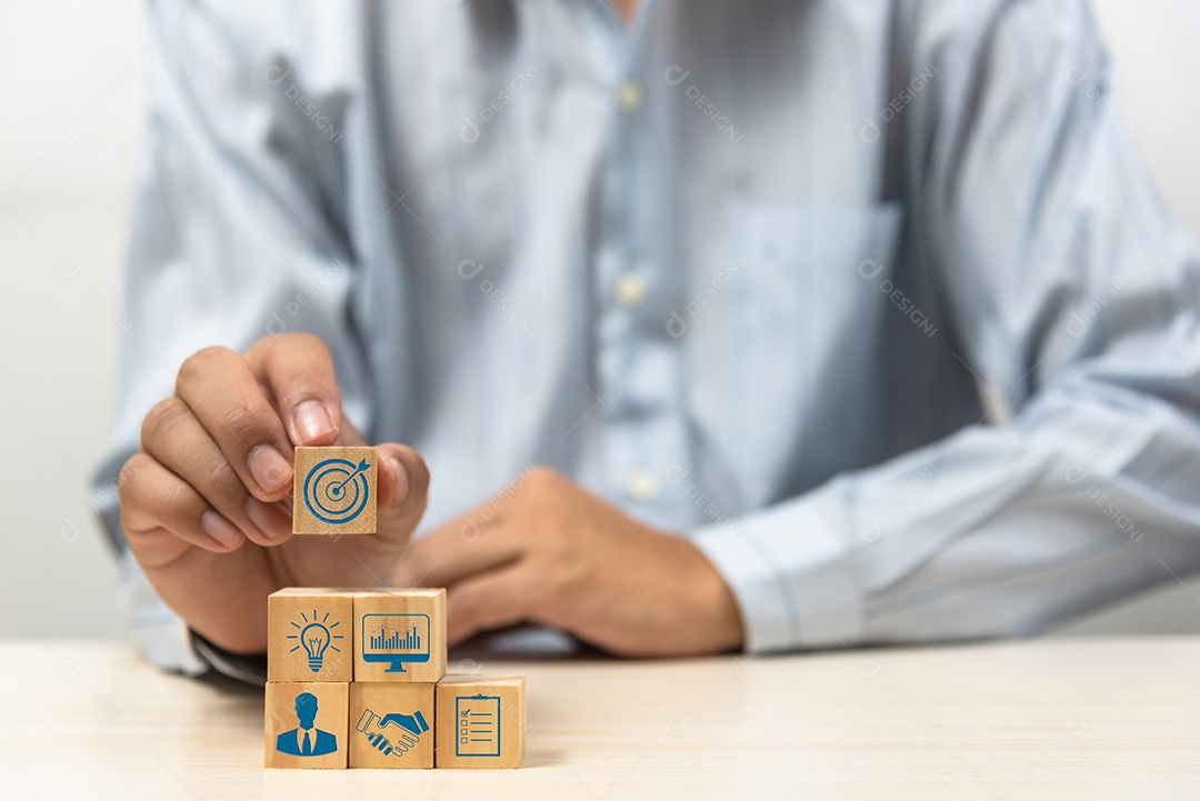 Estratégia de negócios Plano de ação Ícones de objetivo e alvo com mão empilhar um bloco de cubo de madeira em uma mesa. Copie o conceito de inicialização de desenvolvimento da empresa espacial.