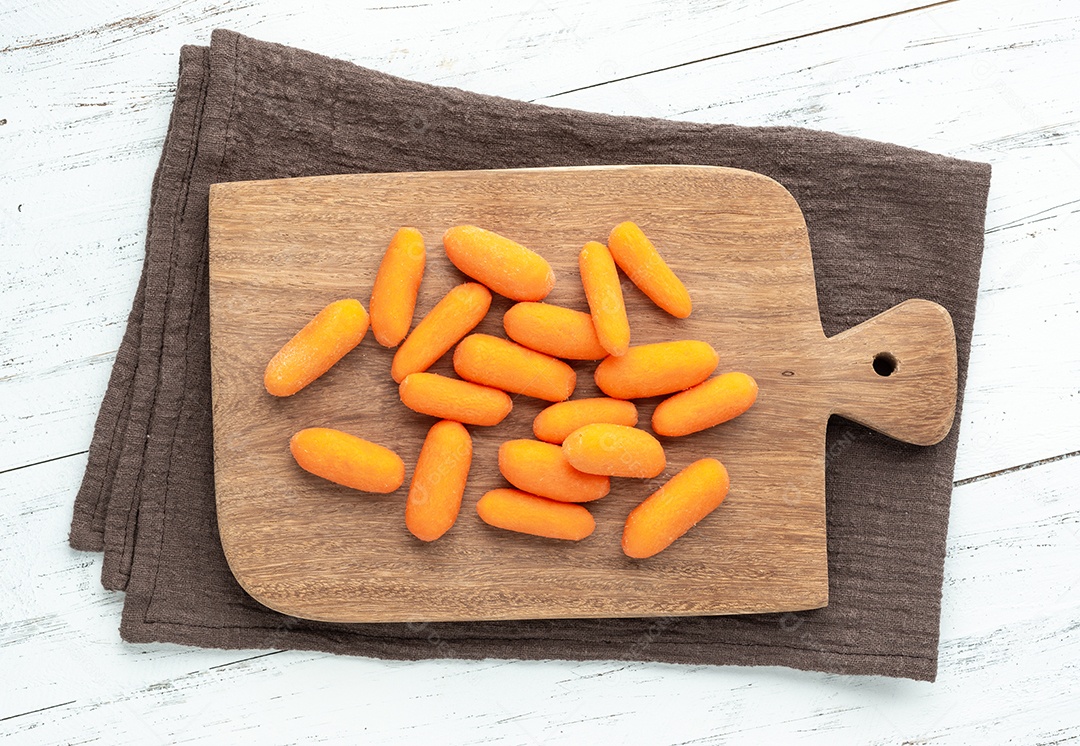 Cenouras em uma placa sobre a mesa de madeira.