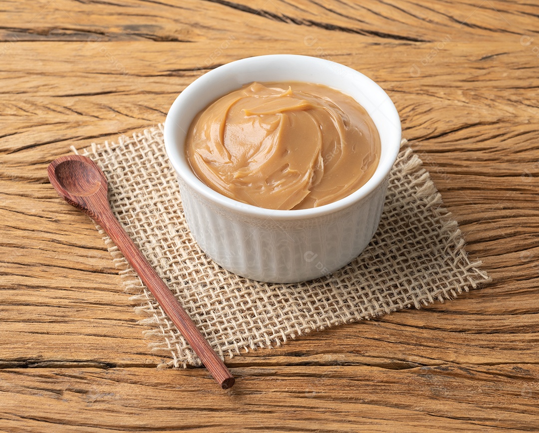 Doce de leite, doce de leite cremoso tradicional brasileiro sobre mesa de madeira.