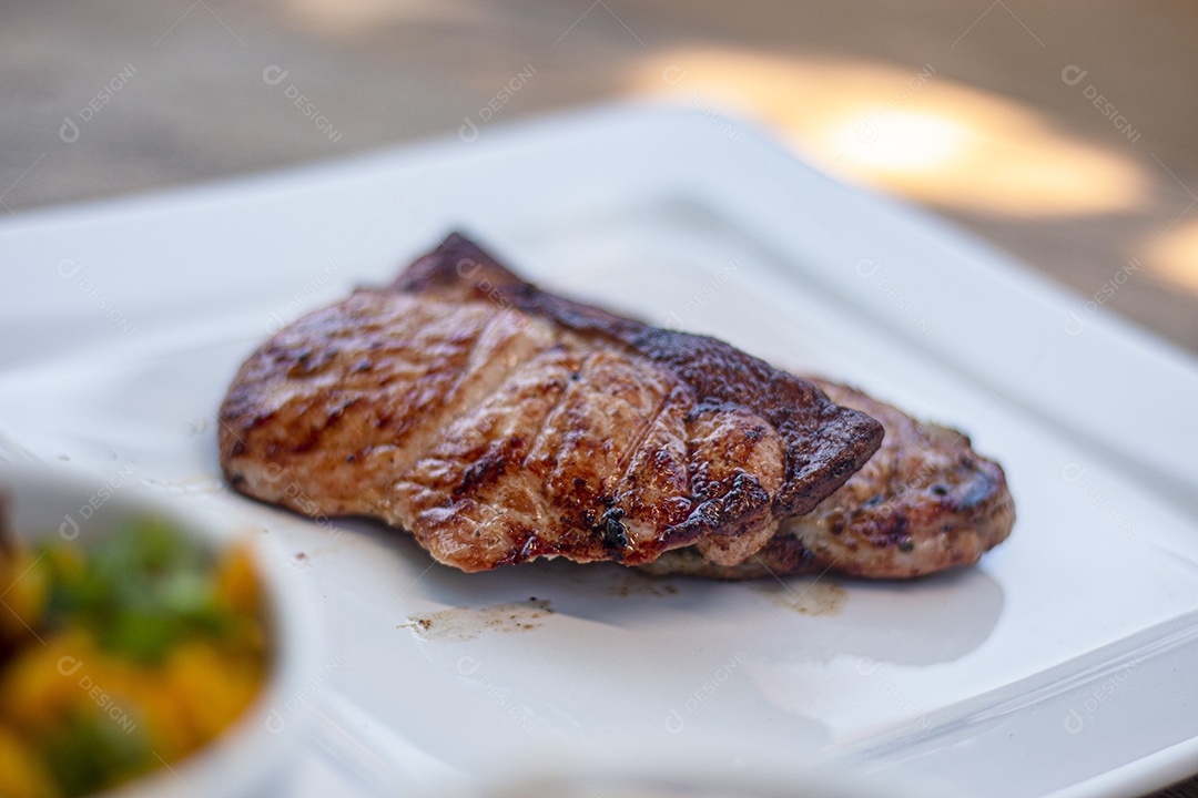 Carne assada suculenta servida em um prato branco
