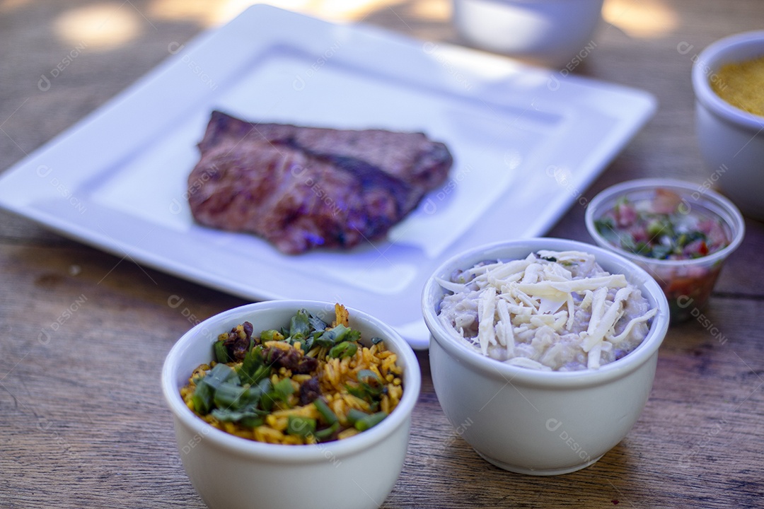 Carne assada suculenta servida em um prato branco com acompanhamentos