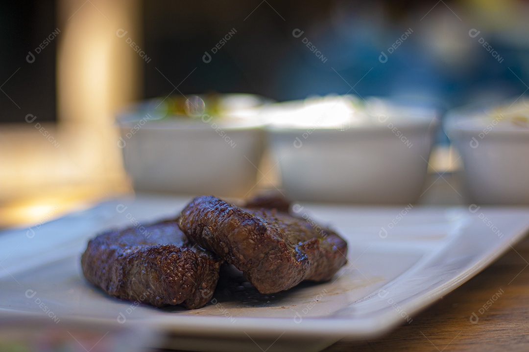 Carne assada suculenta servida em um prato branco com acompanhamentos