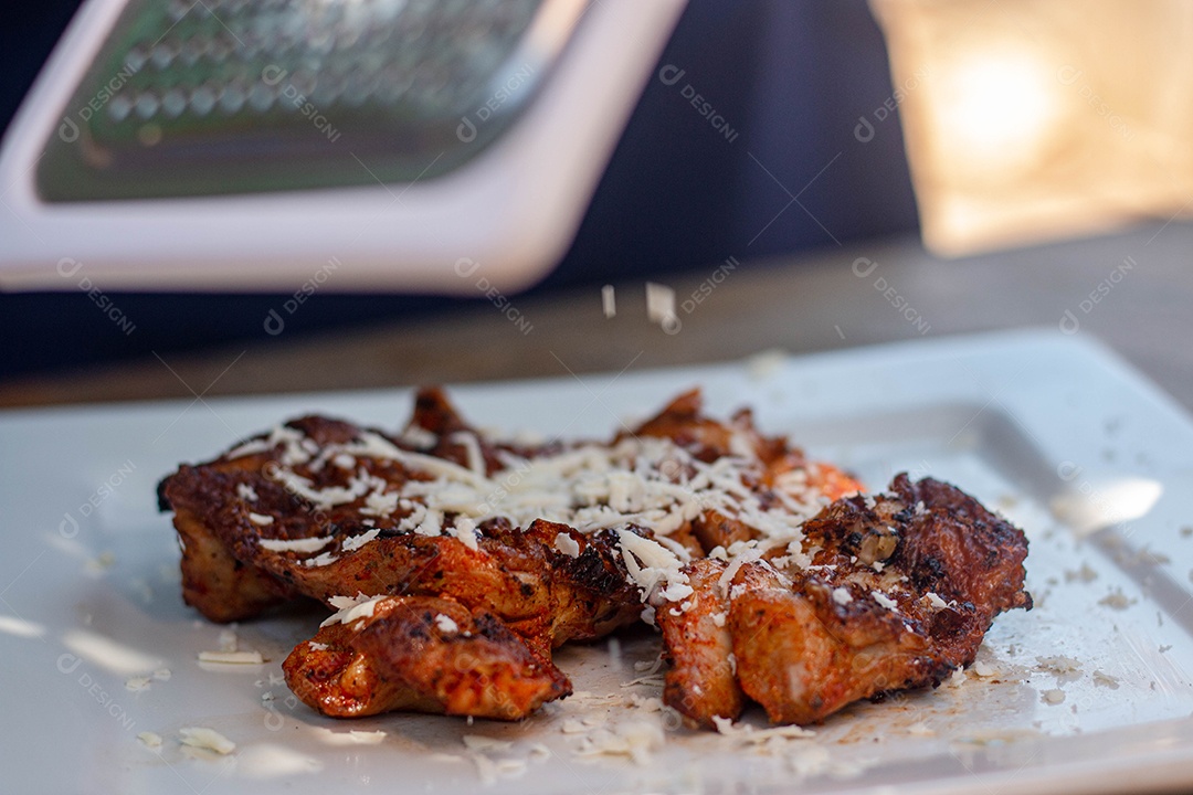 Carne assada suculenta com queijo servida em um prato branco com acompanhamentos